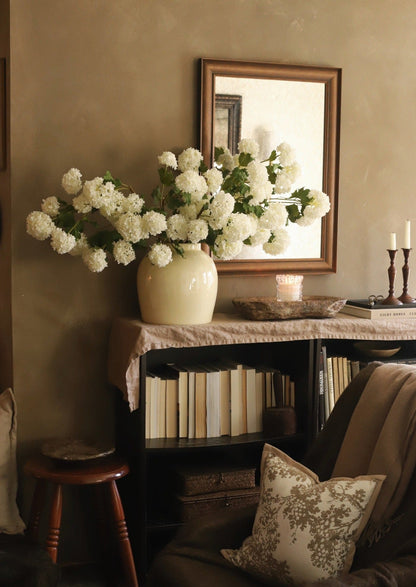 artificial white spring snowball flowers in glossy cream vase